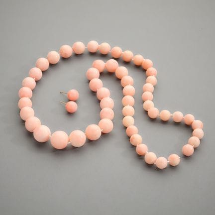 Trio，香港。 一条由53颗渐变尺寸的天使皮珊瑚珠串成的项链，采用穿线打结工艺。一对镶嵌于黄金耳钉