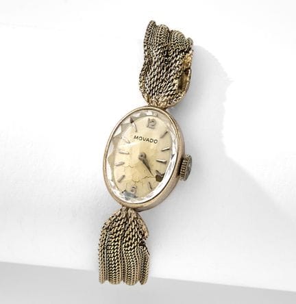 Movado，瑞士。这款14k白金鸡尾酒腕表采用椭圆形表壳，配有奶油色表盘，搭配白金网状表带。表壳和