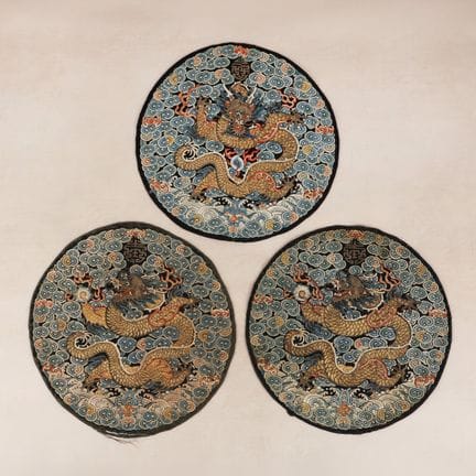Three Chinese embroidered silk 'dragon' roundels, 