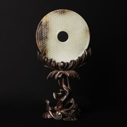 A fine Chinese celadon and russet jade disc, bi, W