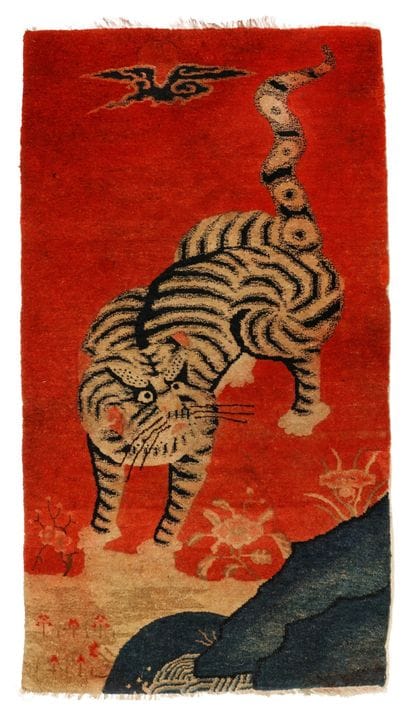 A Chinese Ningxia red-ground 'tiger' rug, Qing dyn