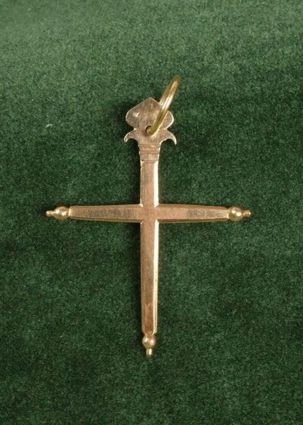 Croix plate en or 750 surmontée d'une fleur de lys