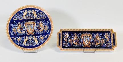 GIEN，20世纪，釉面陶质蛋糕盘，蓝色底色上饰有怪诞图案，背面有品牌标记（一个提手后部有轻微磕碰／