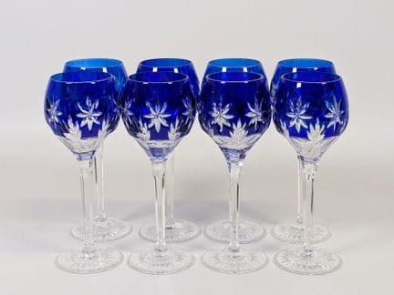 德国，20世纪，一套（x8）刻花水晶高脚杯，部分呈蓝色，每只杯底均带有圆形印记（高：21.5厘米）。