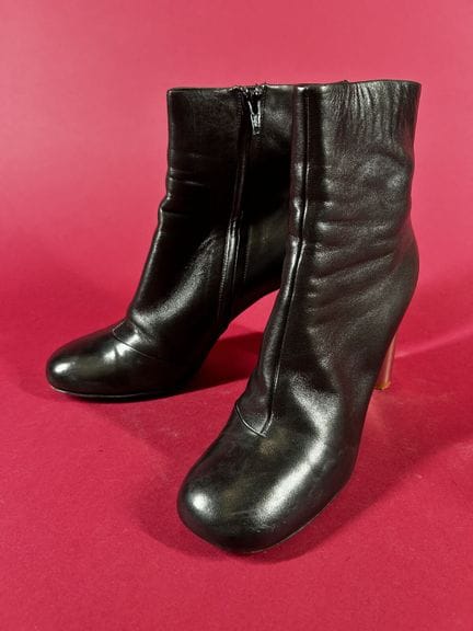 CÉLINE 
一双黑色皮质短靴，配9.5厘米高的银色金属鞋跟。 
（曾穿过，有受潮痕迹。） 
尺码