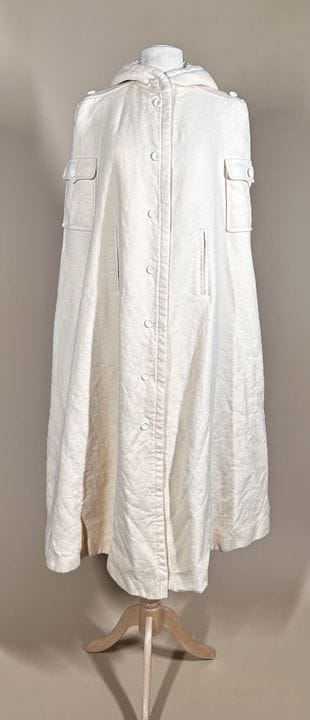 COURRÈGES Paris
奶油色羊毛加巴甸面料长斗篷，带兜帽，两个带按扣翻盖的贴袋，两个开衩，