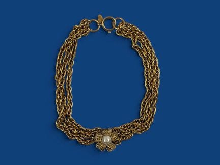CHANEL 
A three-strand necklace made of gold-tone 