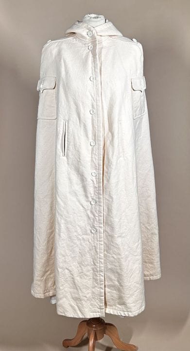 COURRÈGES Paris
米色羊毛加巴甸长斗篷，带兜帽，两个带纽扣翻盖的贴袋，两个开衩，背面有