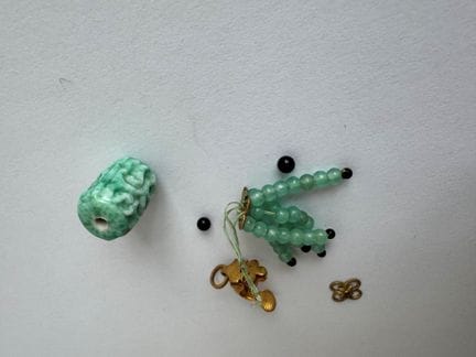 金色金属夹式吊坠，配有珍珠串饰和一枚绿色硬石制成的亚洲风格小饰牌（瑕疵）