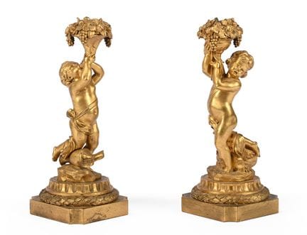 UN PAR DE CANDELABROS DE BRONCE DORADO CON FORMA D