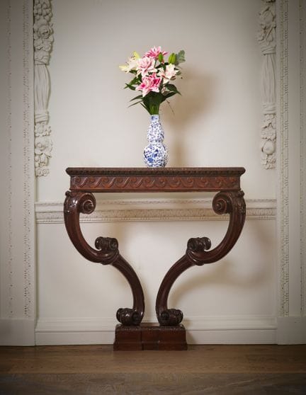 UNE TABLE CONSOLE EN ACAJOU SCULPTÉ DE L'ÉPOQUE DE