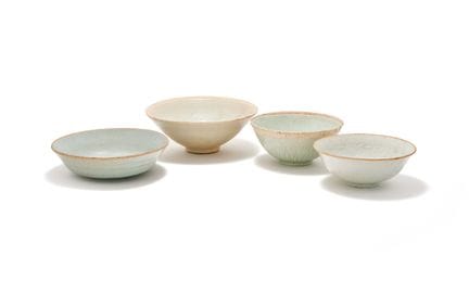 一套四只中国青白瓷碗，包括：一只元代中国青白瓷碗，碗身饰有浮雕花卉纹样，通体覆以浅色青釉，内壁造型精