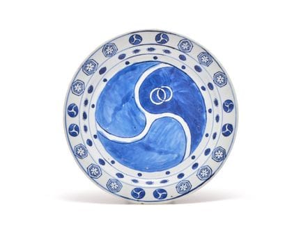 一件中国青花“古染付”盘，约1650年制，中央饰有三点纹家徽，边缘饰有纹样，直径21.5厘米。十七世