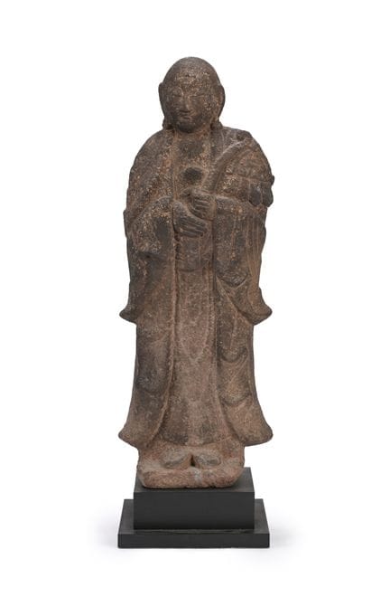 Eine große, geschnitzte Steinfigur eines stehenden