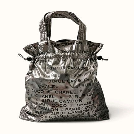 CHANEL. Borsa in tela argentata con la scritta "Co