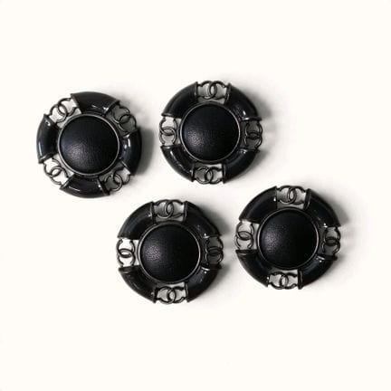 CHANEL. Set of four round buttons in black metal a
