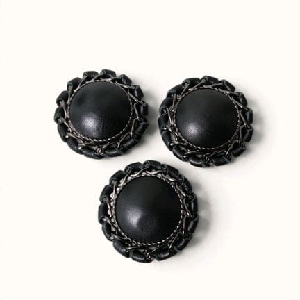 CHANEL. Set of three round, domed buttons, covered