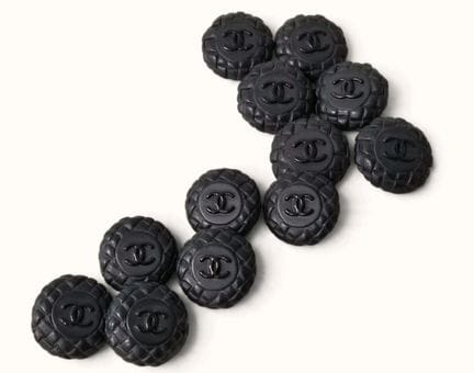 CHANEL. Set of twelve round black metal buttons wi