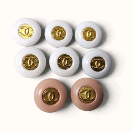 CHANEL. Set of eight round, domed buttons in powde
