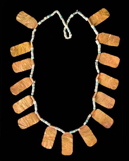 Una collana di perline con placchette d’oro,
Ispir