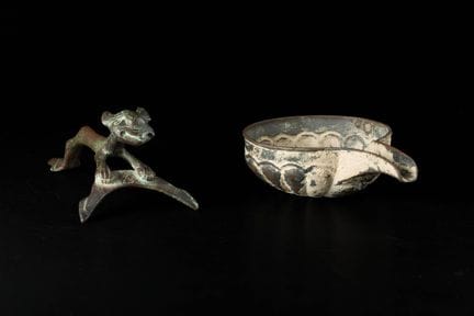 Un manico in bronzo a forma di felino e un recipie