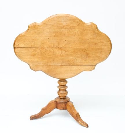 Natural wood table with a curved tilting top and t