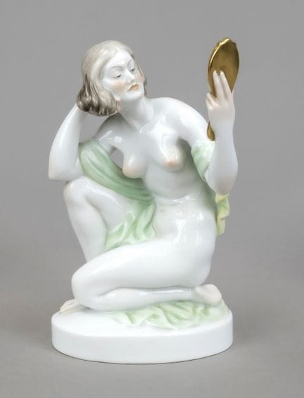 手持手镜的跪姿女性裸体雕像，赫伦德（Herend），20世纪，彩釉装饰并饰以镀金，椭圆形底座上署有S