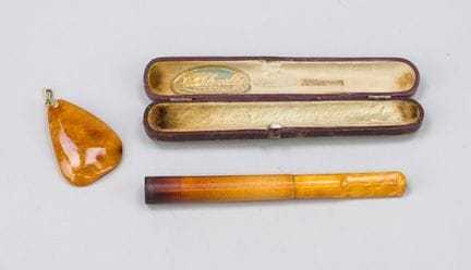 Embout de cigarette en ambre et pendentif muni d'u