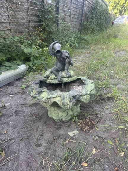 Statue de jardin représentant un singe tenant une 