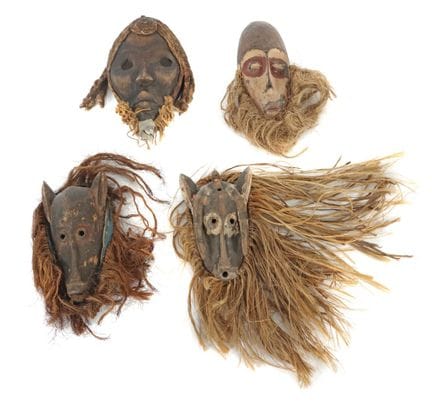 Quatre masques africains sculptés dans le bois, en