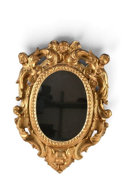 MIROIR en bois sculpté et doré à décor de tête de 