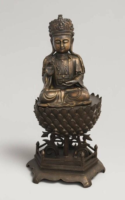 Guanyin aus Bronze mit brauner Patina, sitzend
auf