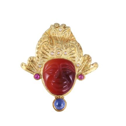 * 18K yellow gold pendant depicting a mask with a 