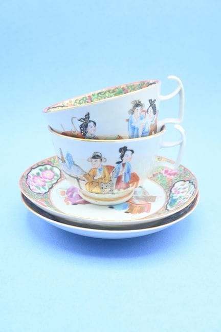 Dos tazas y sus platillos de porcelana con motivos