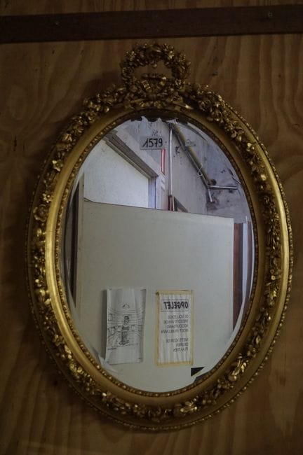 Beautiful oval gilded mirror—richly decorated with