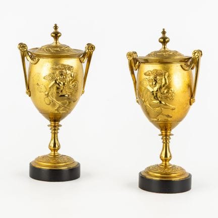 Coppia di cassolettes o urne decorate con putti da