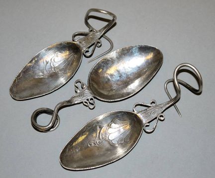 Three silver ‘tupu’, spoon-shaped garment pins, a 