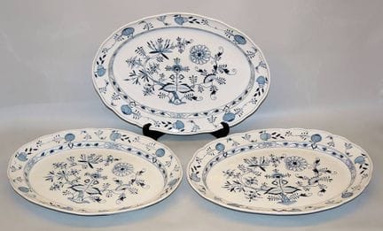 Three very large serving platters with an onion pa