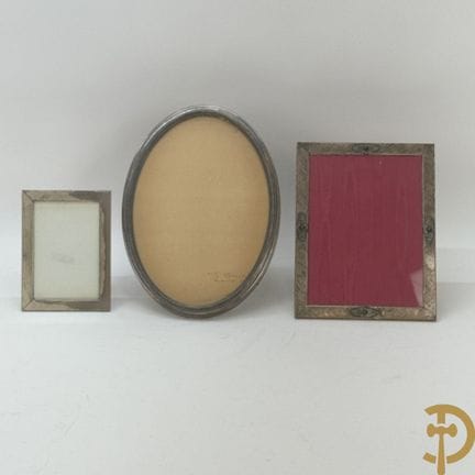Two rectangular and one oval photo frames in a sol