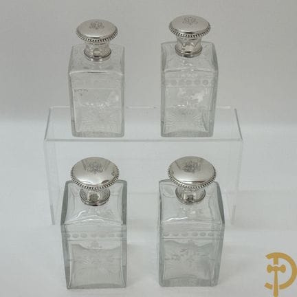 Four carafes with a cut floral motif and solid sil