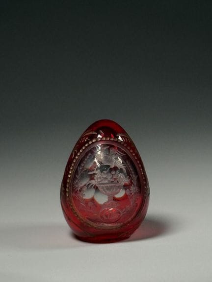 Crystal egg carved with an eagle perched atop a cu