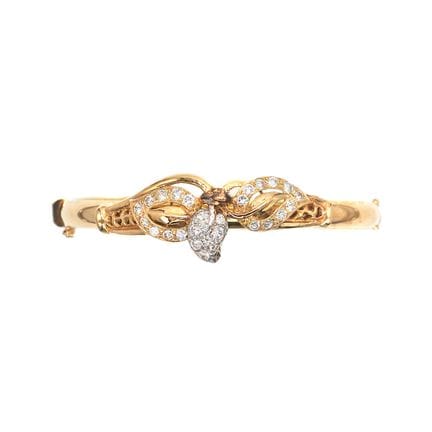 BRACELET jonc en or 18K, décor végétal serti de di