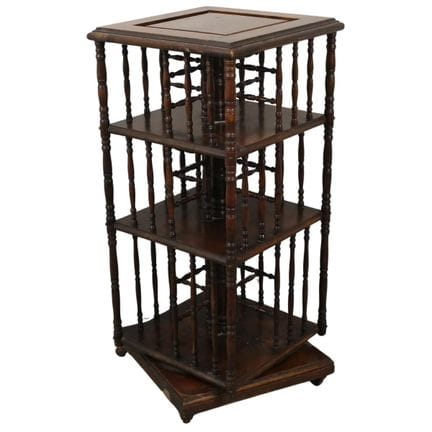 Carved walnut rotating bookcase with side columns.