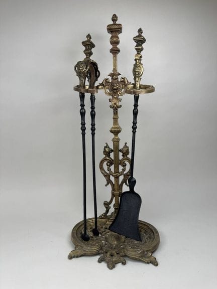 A gilded, chiseled bronze fireplace set decorated 