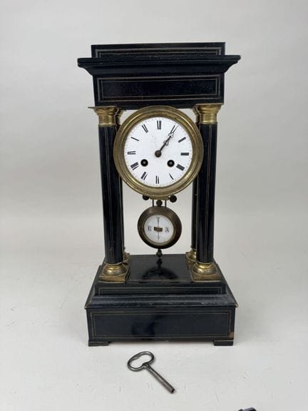 Blackened wood and brass pendulum clock with a cir