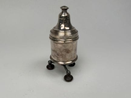 Small silver plated metal pepper mill with a tripo