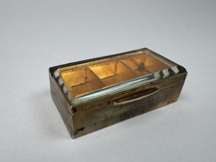 Small brass stamp box with a beveled glass lid and