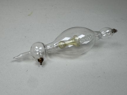 Geissler tube made of glass with a bulging body. 
