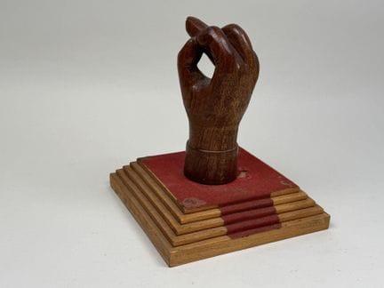 Mano in legno intagliato e patinato, appoggiata su