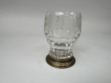 Glass cup with engraved vine leaves; brass base.
H